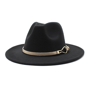 Détail d'un chapeau fedora en laine noire avec bande en cuir beige et boucle fer à cheval