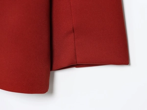 Detailed macro view of the double-breasted red blazer cuff with neat stitching and fabric texture