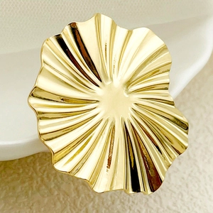 Detailed close-up of a golden wavy lotus leaf texture on a metal fashion accessory