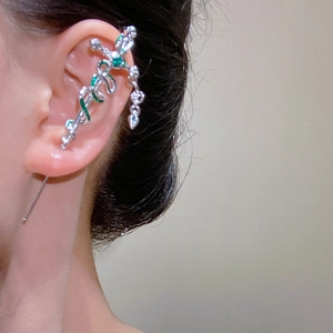 Gothic silver sword and green snake ear crawler earring worn on a female model