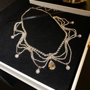 Detail of a multi-layer silver necklace with rhinestones and pearls in a black jewelry box