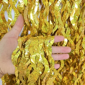 Close-up of gold S-shaped foil fringe curtain with shimmering wavy metallic texture