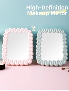 Detail of pink and grey wavy desktop makeup mirrors with matte frames and clear glass
