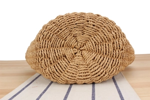 Detailed close-up of woven straw bag bottom showing intricate spiral natural fiber texture