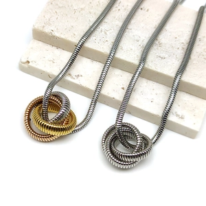 Detail of round snake chain necklaces with interlocking triple-ring pendants in gold and silver