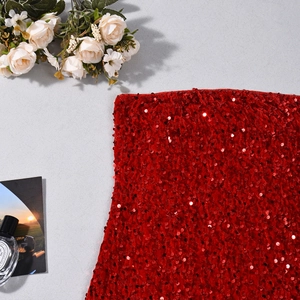 Gros plan détaillé sur la texture des paillettes rouges avec des accessoires élégants
