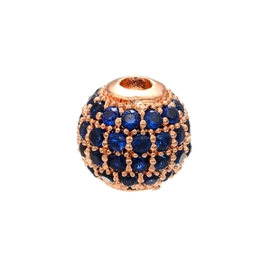 Makroaufnahme einer roségoldenen Perle mit dunkelblauen Kristallen für DIY-Schmuck