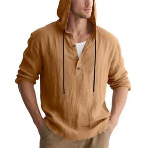 Detail of yellow linen hooded shirt showing fabric texture, buttons, and drawstrings