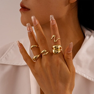 Detail of four-piece gold irregular geometric stackable rings on female fingers