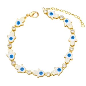 Golden Hamsa Hand bracelet with white enamel evil eye charms and sparkling zircons