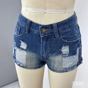 Gros plan détaillé d'un short en jean usé avec bords effilochés et bouton en laiton