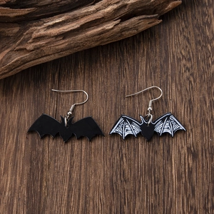 Detailed close-up of Gothic bat wings earrings with bone patterns on a dark wooden background