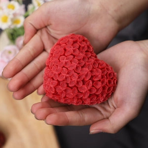 Detailaufnahme einer roten herzförmigen Kerze mit feinen floralen Texturen