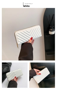 Détail du portefeuille blanc matelassé en V avec une fermeture éclair dorée élégante