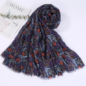 Detail of navy cotton linen scarf with colorful leaf prints and elegant fringe edges