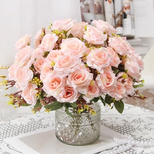 Artificial pink roses in a textured glass vase with pearls for elegant home decoration