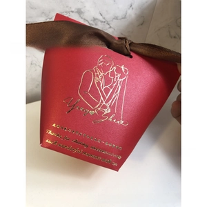 Detail view of red wedding gift box with gold foil illustration and brown ribbon