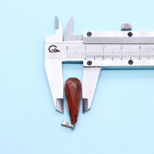 Macro view of teardrop natural stone pendant being measured with a caliper for 10mm width