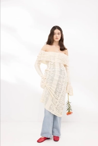 Detail of off-shoulder cream knit dress featuring intricate hollow-out floral patterns