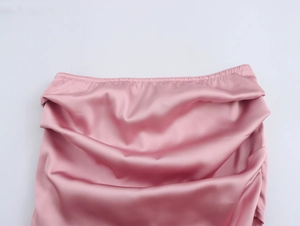 Détail du tissu en satin rose montrant la texture plissée élégante et la taille