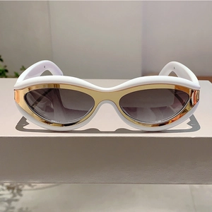 Close-up of white wide-frame Y2K cat-eye sunglasses with gold metal accents and grey lenses