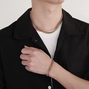 Men's two-tone gold and silver Cuban link chain necklace and bracelet set on model