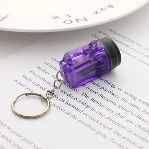 Detail of purple transparent oil drum keychain with metal ring on printed background