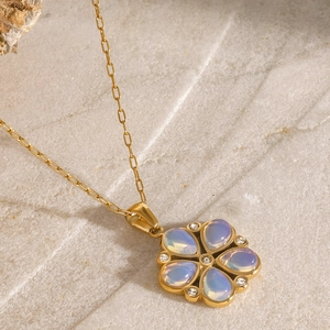 Macro detail of gold flower pendant necklace with opal petals and zircon accents