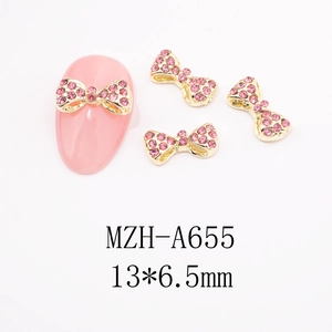 Close-up of pink rhinestone bow nail art charm with gold alloy base and dimensions