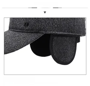 Detail view of winter baseball cap with ear flaps and wool-like texture in dark grey
