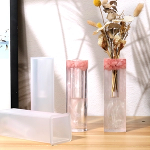Detail of rectangular and cylindrical silicone molds with floral resin finished crafts