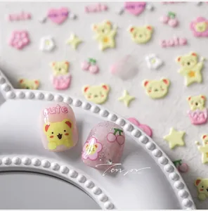 Detailed macro of 5D cartoon nail stickers featuring cute bears and pink floral designs