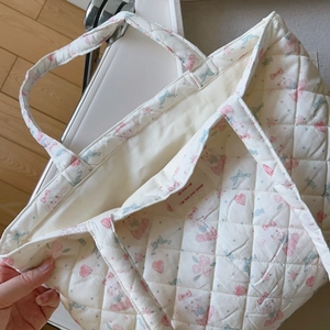 Detail der gesteppten Baumwolltasche mit Rosen-, Hasenprint und französischem Webetikett