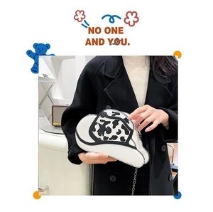 Detail of creative cowboy hat crossbody bag with cow print and black star accent