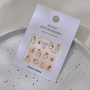 Close-up of 3D nail art stickers with pearls and crystals on professional white card