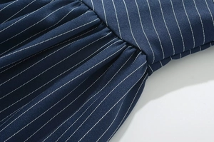 Détail du tissu à rayures verticales bleu marine avec plissage précis et texture fine