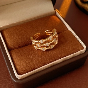 Macro detail of a triple-layered gold bamboo-style ring with shimmering zircon inlays