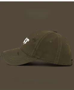 Detail view of distressed army green baseball cap with letter embroidery and worn edges