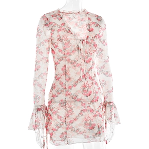Détail de robe florale avec col en V, motifs de roses et laçage délicat sur le devant