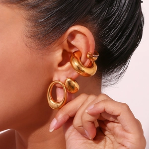 Detailed view of irregular 18K gold plated heart earrings on model's ear