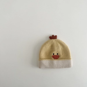 Detailed knit texture of a yellow baby chicken beanie with 3D red comb and cute face