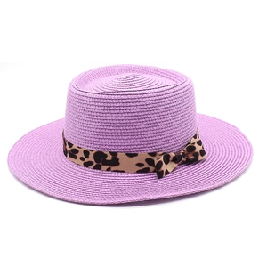 Close-up of purple straw sun hat featuring a leopard print ribbon and side bow detail