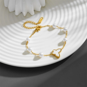 Golden stainless steel bracelet featuring white pearls and a butterfly clover charm