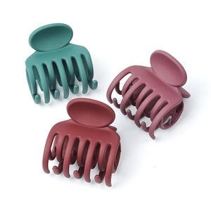 Three matte solid color hair claw clips in dark green, purple, and burgundy shades