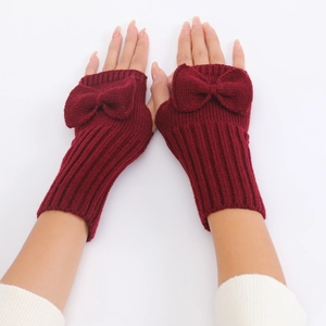Close-up of wine red fingerless knit gloves with large bow accent and ribbed texture