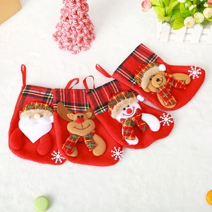 Detail of four red felt Christmas stockings with festive cartoon figures on a plush surface