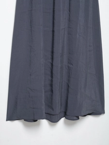 Close-up of dark grey A-line dress fabric with silk-like luster and subtle pleat texture