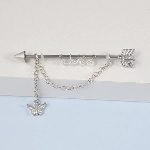 Détail de piercing industriel argenté avec pendentif papillon et perles colorées