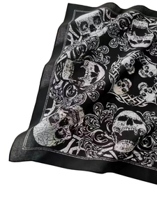 Detailed view of black cotton bandana featuring white skull and paisley floral patterns
