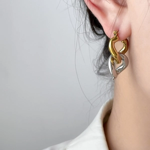 Two-tone curved hoop earrings in gold and silver plating on a female model